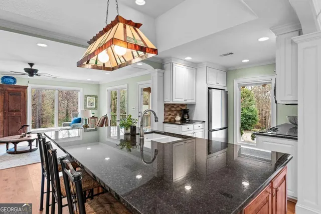 a kitchen with stainless steel appliances granite countertop a refrigerator sink and stove