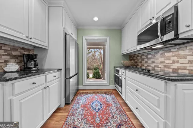 a kitchen with stainless steel appliances granite countertop a sink a stove and cabinets