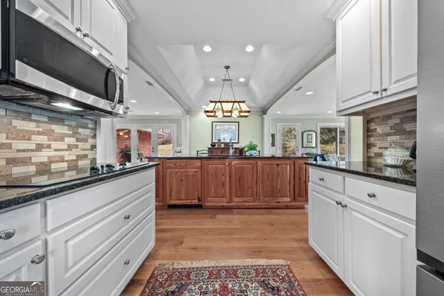 a room with lots of wooden furniture dining table and a chandelier