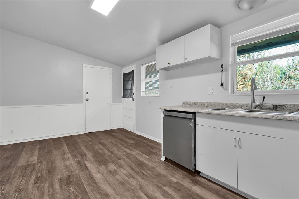 515 Forrest Lane Denison, TX 75021 - Photo 6 of 15 a kitchen with granite countertop white cabinets and a wooden floor