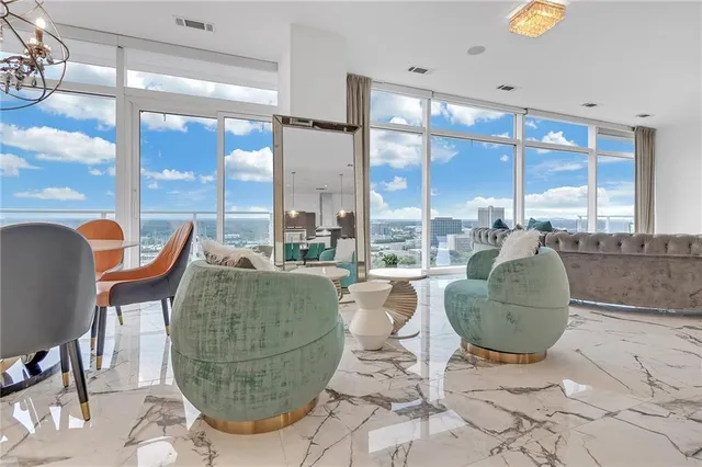 a living room with couches and a dining table with garden view