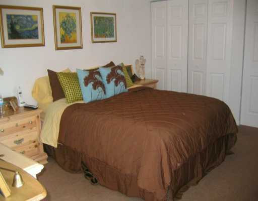 8231 B Thames Boulevard, Unit B Boca Raton, FL 33433 - Photo 8 of 10 a bed sitting in a bedroom next to a cabinet
