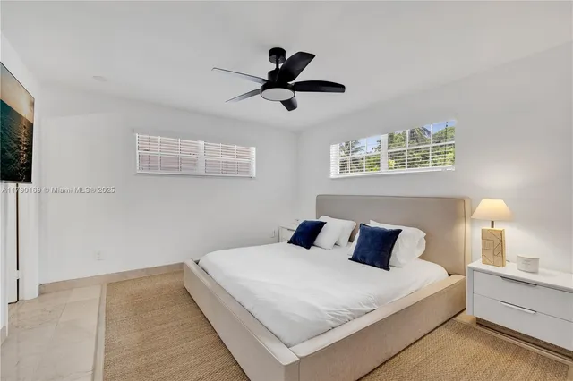 a bedroom with a large bed and a ceiling fan