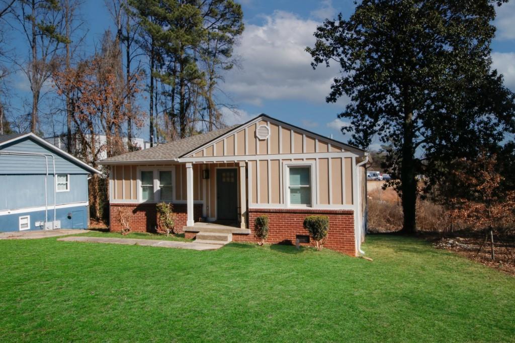 a front view of a house with a yard and trees