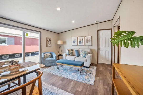 a living room with furniture floor to ceiling window and wooden floor