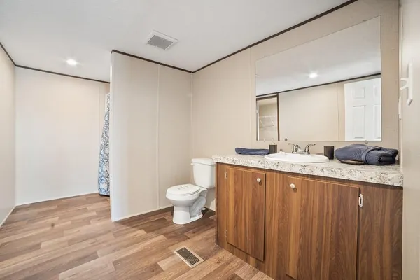 a bathroom with a granite countertop sink toilet and shower