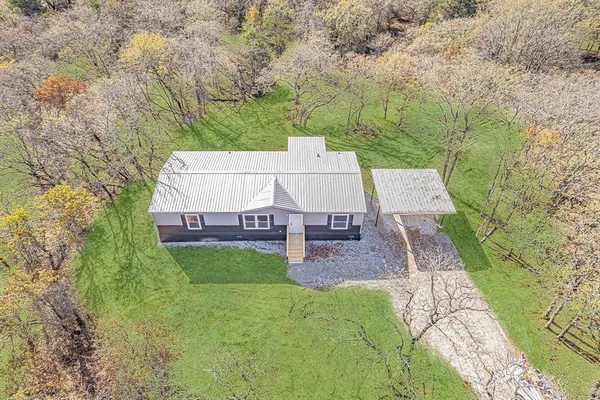 an aerial view of a house with garden space and trees