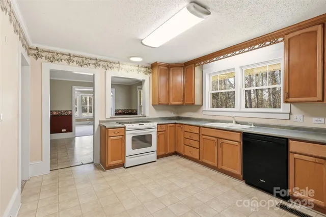 a large kitchen with granite countertop a sink and cabinets