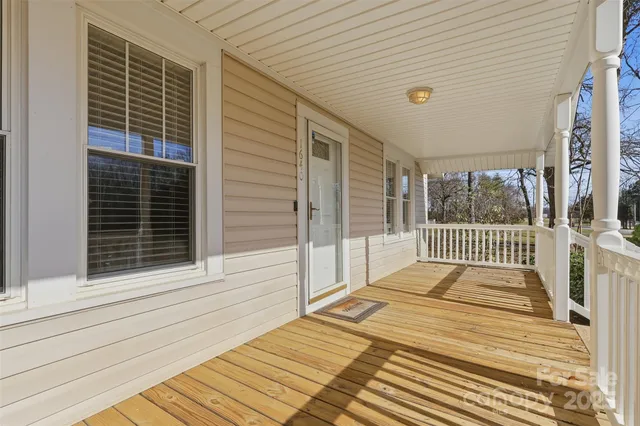 a view of a patio with table and chairs with wooden floor and fence
