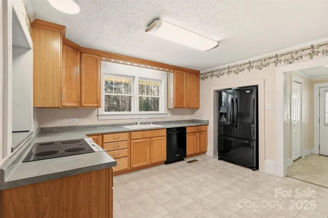 a kitchen with granite countertop a refrigerator and a stove
