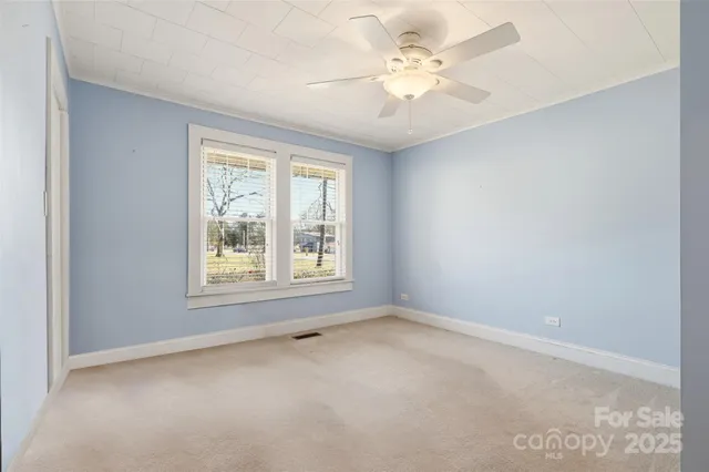 an empty room with a ceiling fan and a window