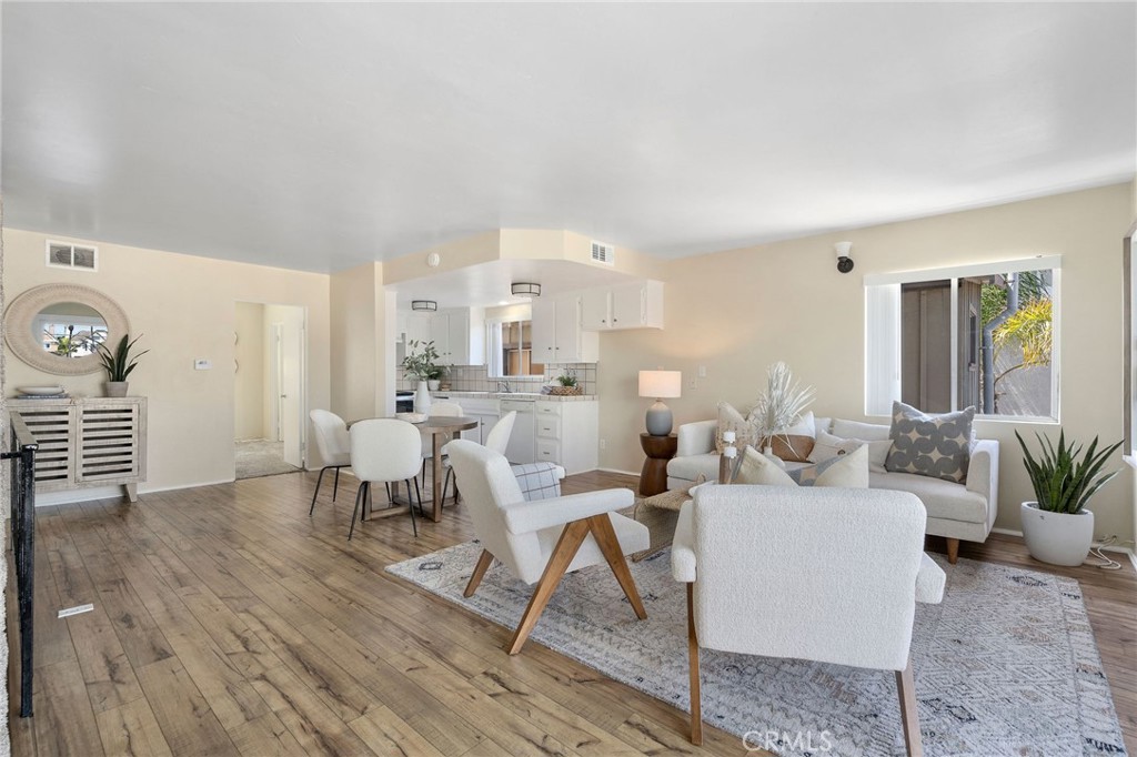 19 B Surfside Surfside, CA 90743 - Photo 5 of 35 a living room with couches chairs and kitchen view with wooden floor
