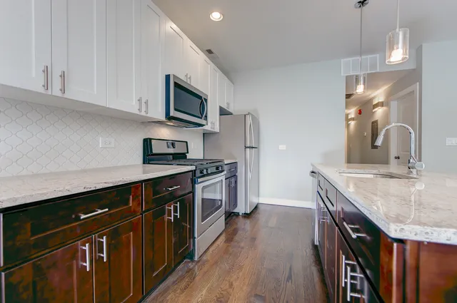 a kitchen with stainless steel appliances granite countertop a sink stove and refrigerator