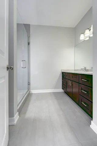 a view of an empty room with cabinet and mirrors