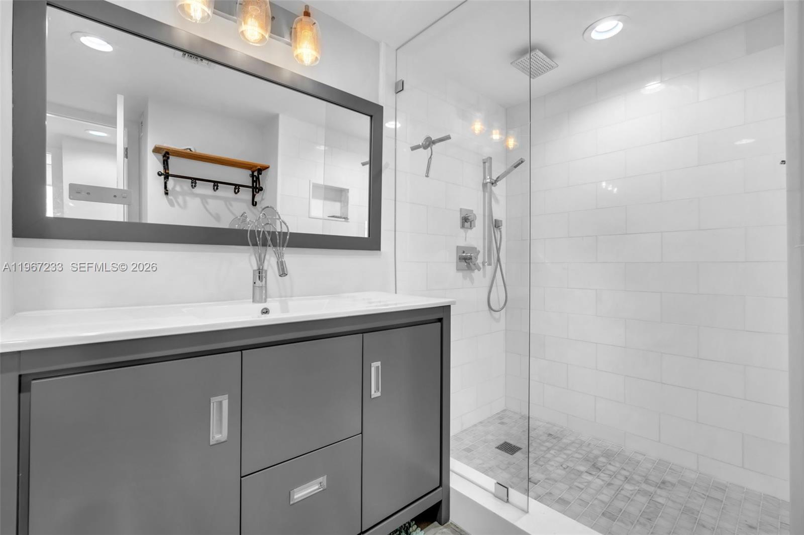 7135 Collins Avenue, Unit 736 Miami Beach, FL 33141 - Photo 14 of 27 a bathroom with a shower sink and mirror