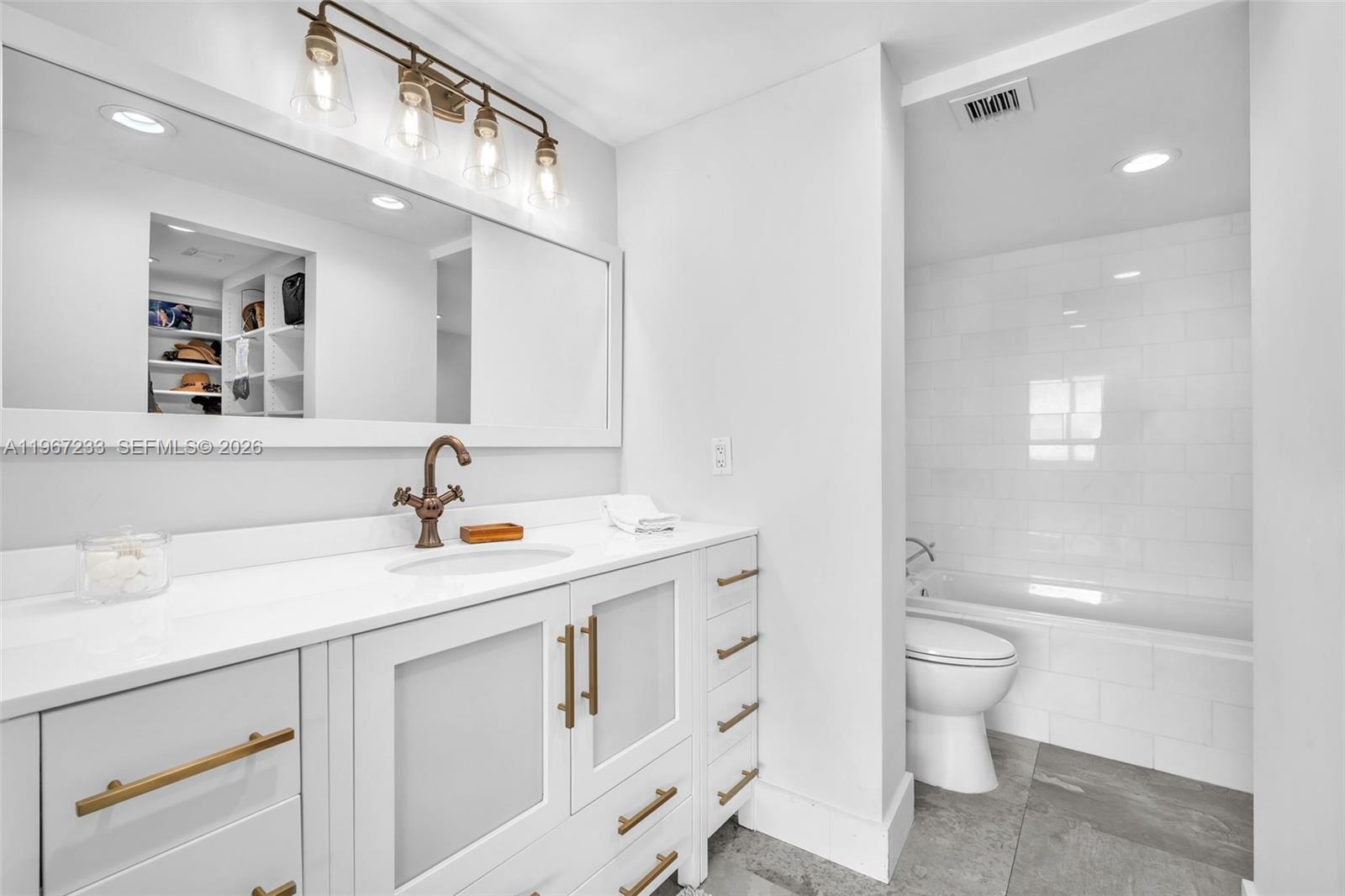 7135 Collins Avenue, Unit 736 Miami Beach, FL 33141 - Photo 18 of 27 a bathroom with a sink a toilet and a mirror
