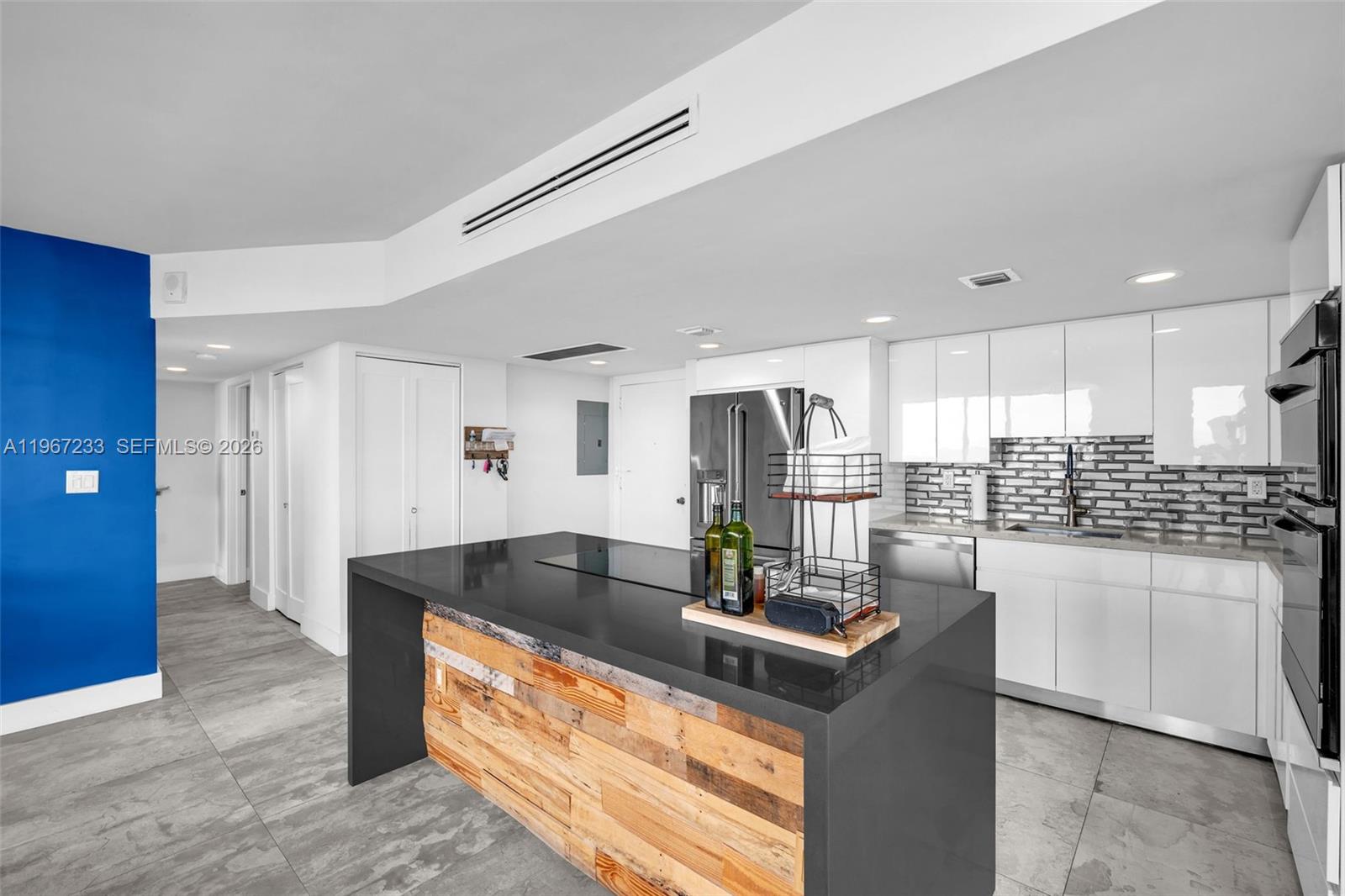 7135 Collins Avenue, Unit 736 Miami Beach, FL 33141 - Photo 6 of 27 a kitchen with stainless steel appliances granite countertop a sink and a refrigerator