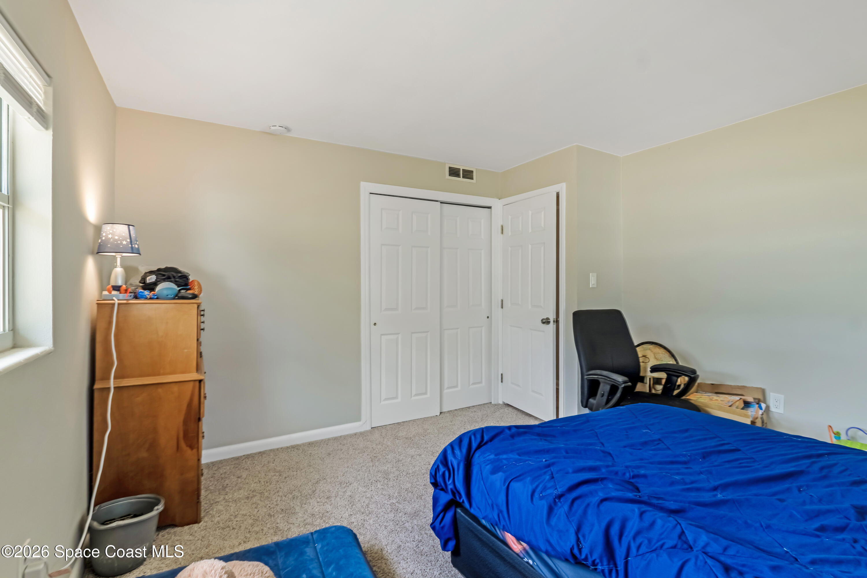 220 Alhambra Street Titusville, FL 32780 - Photo 12 of 29 a bedroom with a bed and a mirror