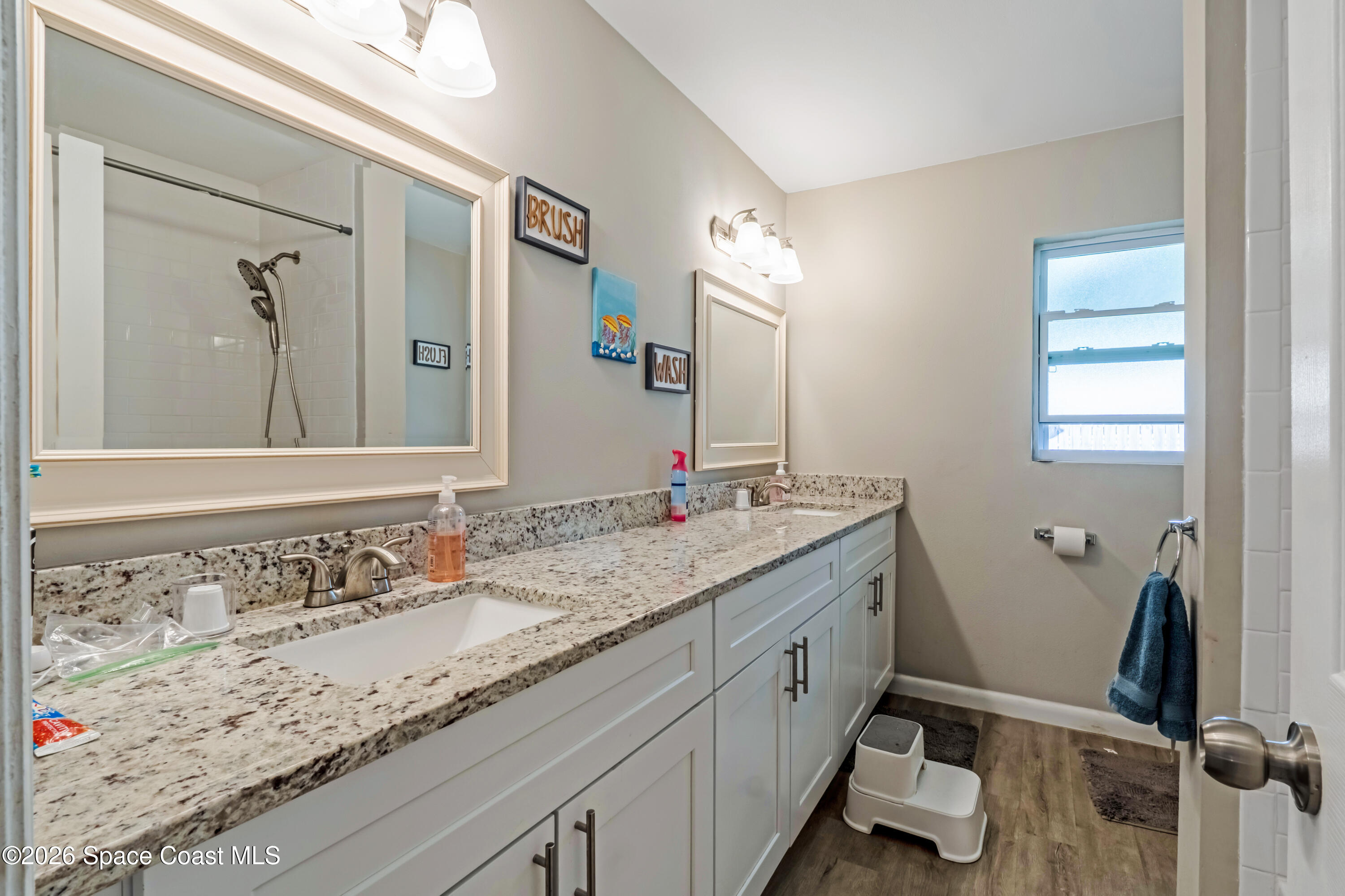 220 Alhambra Street Titusville, FL 32780 - Photo 17 of 29 a bathroom with a granite countertop sink mirror and double