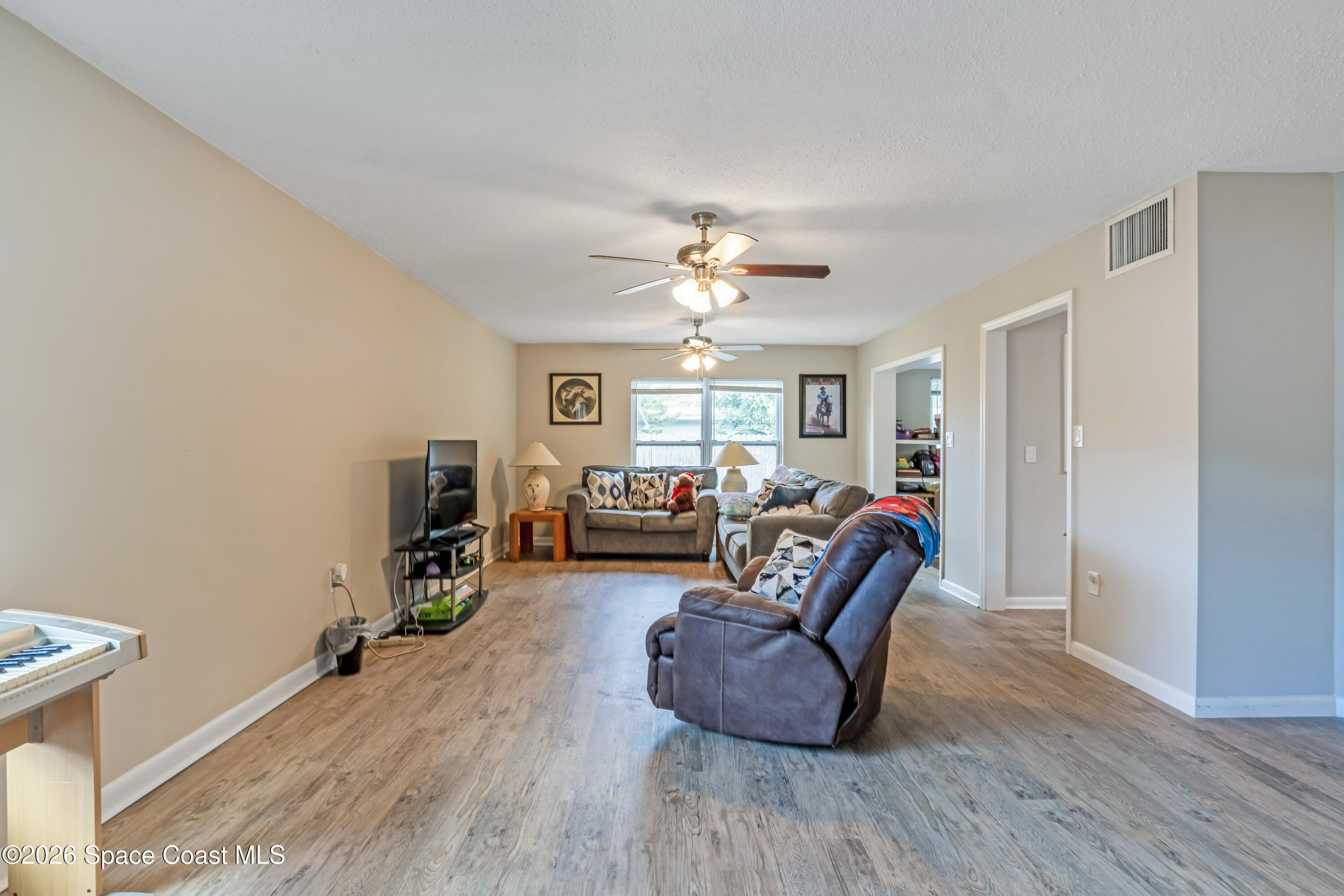 220 Alhambra Street Titusville, FL 32780 - Photo 26 of 29 a living room with furniture and a flat screen tv