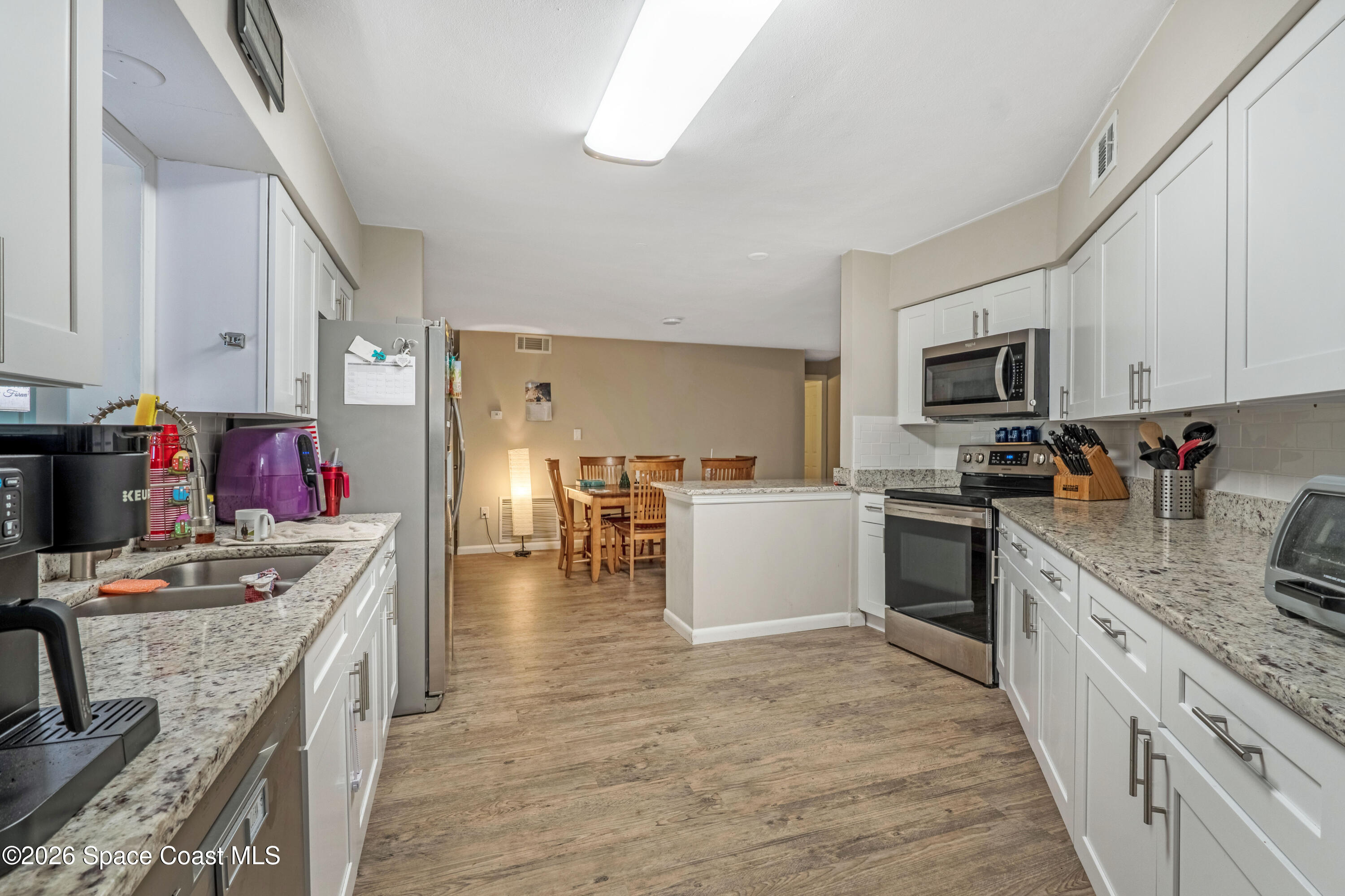 220 Alhambra Street Titusville, FL 32780 - Photo 29 of 29 a kitchen with granite countertop a sink stove top oven and cabinets