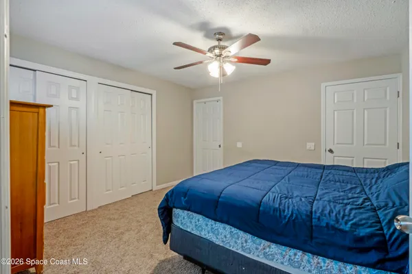 a spacious bedroom with a bed and a ceiling fan