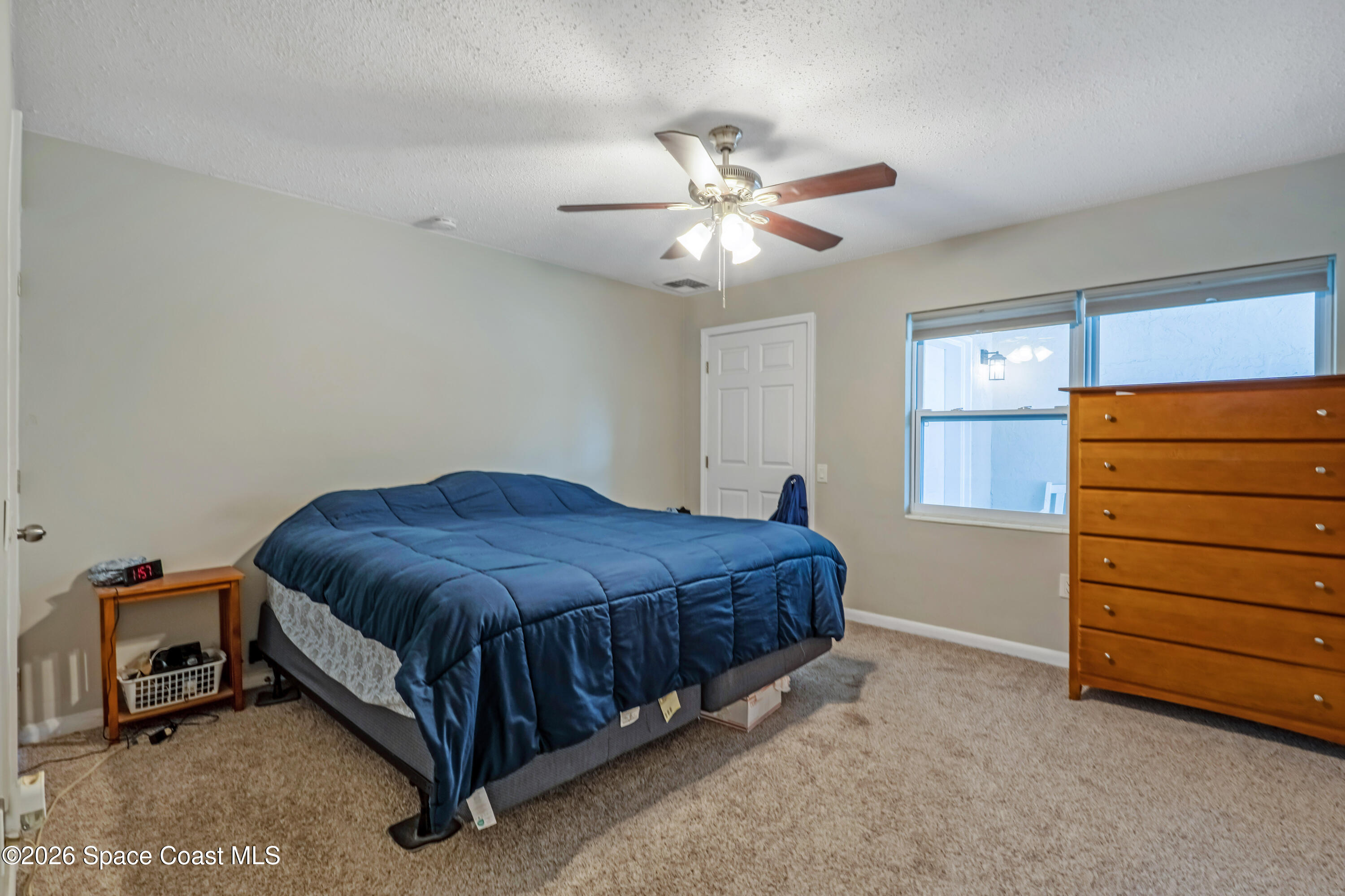 220 Alhambra Street Titusville, FL 32780 - Photo 9 of 29 a spacious bedroom with a bed and a ceiling fan