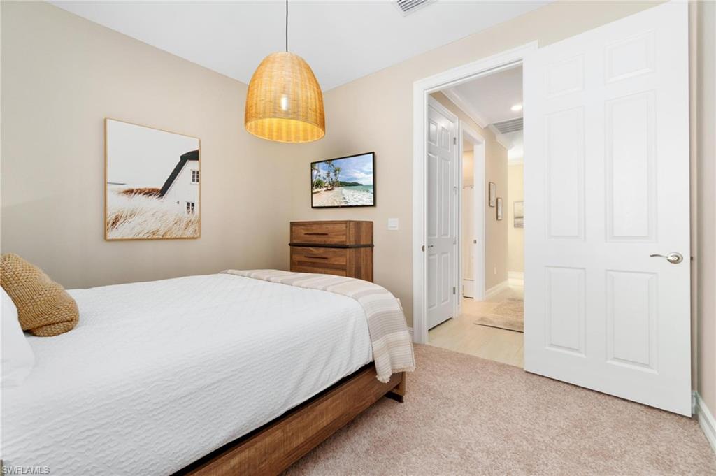 28298 Captiva Shell Loop Bonita Springs, FL 34135 - Photo 11 of 49 a bedroom with a bed and a chandelier
