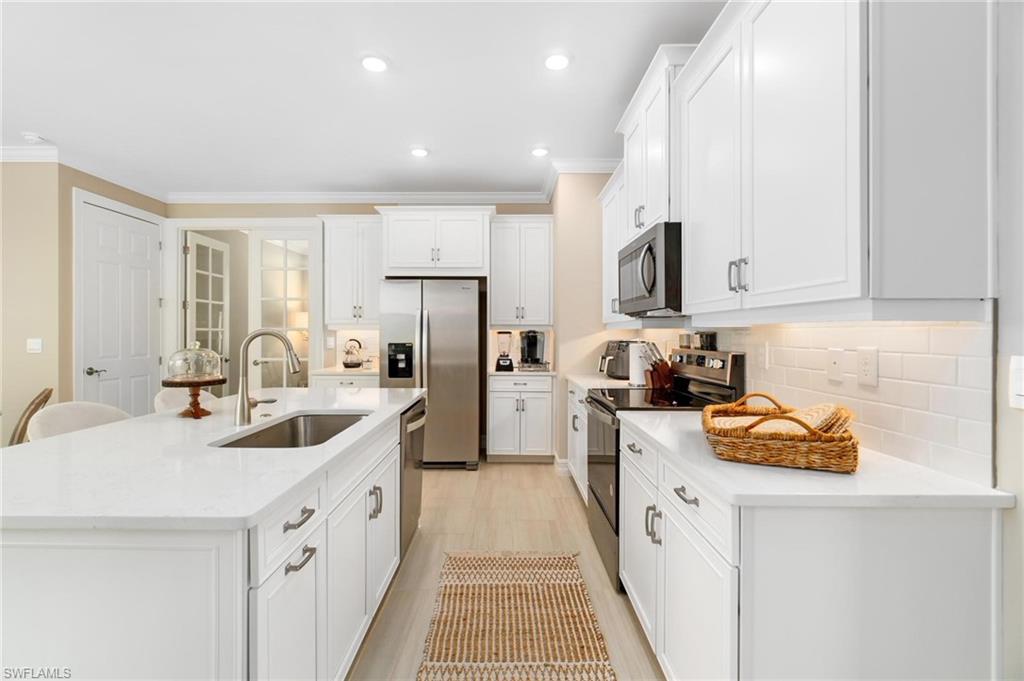 28298 Captiva Shell Loop Bonita Springs, FL 34135 - Photo 12 of 49 a kitchen with stainless steel appliances granite countertop a sink stove and refrigerator