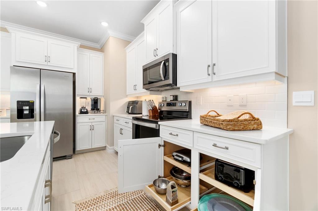 28298 Captiva Shell Loop Bonita Springs, FL 34135 - Photo 13 of 49 a kitchen with stainless steel appliances a stove a microwave a sink and cabinets
