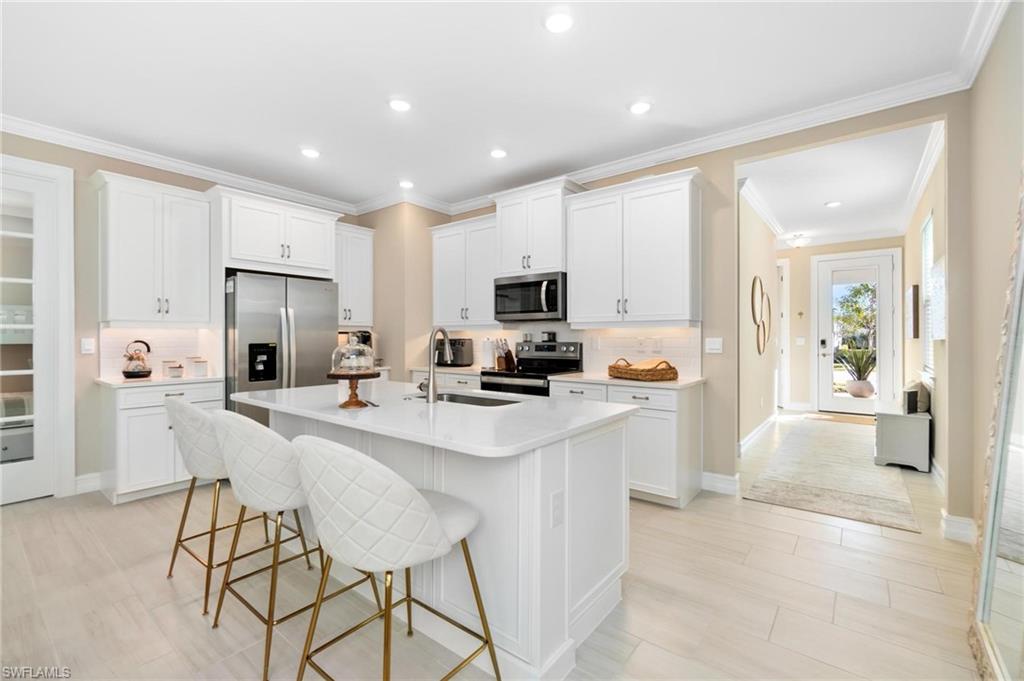 28298 Captiva Shell Loop Bonita Springs, FL 34135 - Photo 14 of 49 a kitchen with stainless steel appliances kitchen island sink refrigerator and microwave