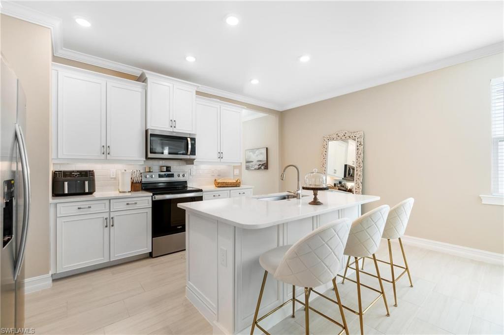 28298 Captiva Shell Loop Bonita Springs, FL 34135 - Photo 16 of 49 a kitchen with white cabinets and stainless steel appliances
