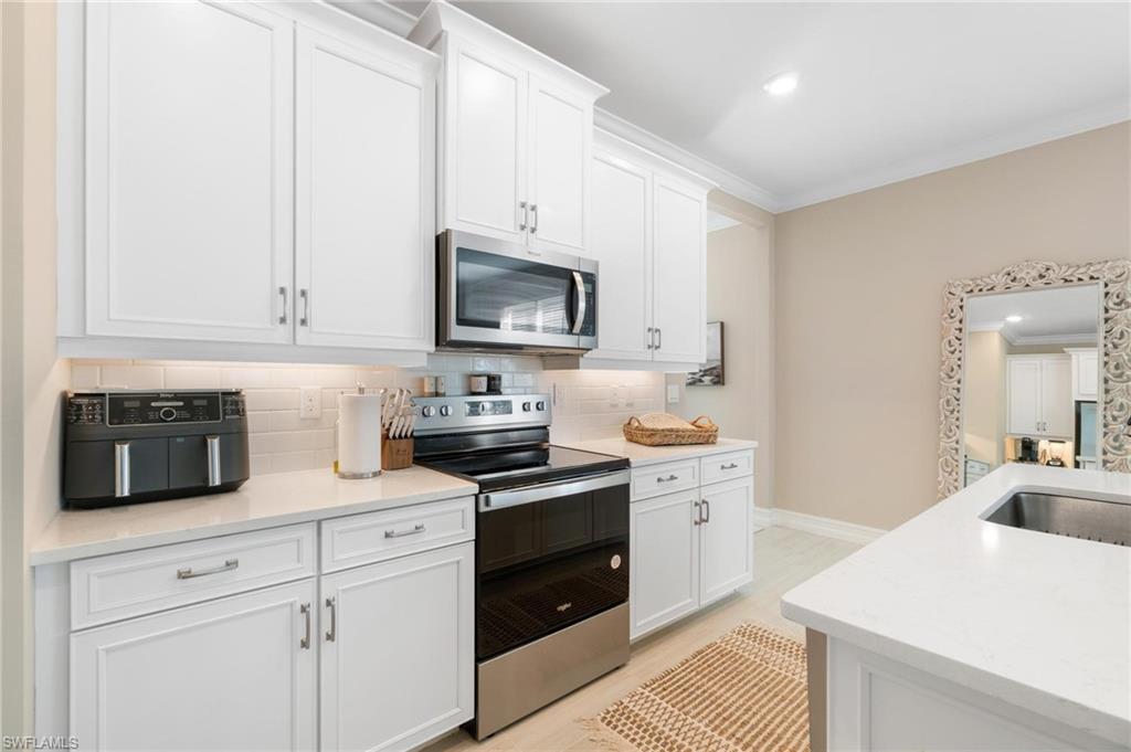 28298 Captiva Shell Loop Bonita Springs, FL 34135 - Photo 18 of 49 a kitchen with granite countertop white cabinets white stainless steel appliances and sink