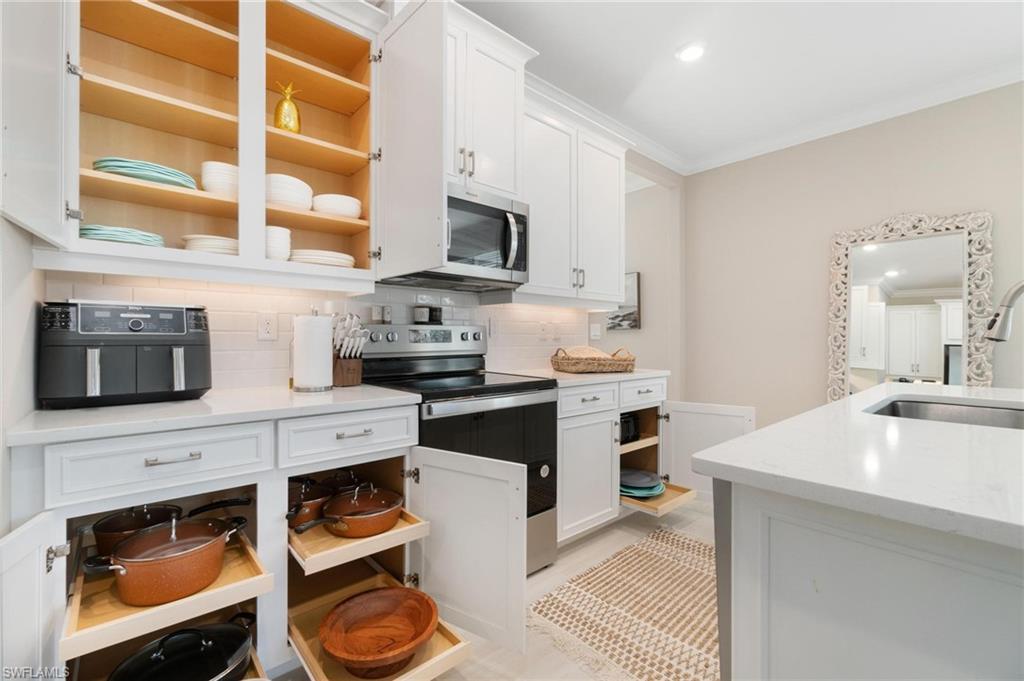 28298 Captiva Shell Loop Bonita Springs, FL 34135 - Photo 19 of 49 a kitchen with stainless steel appliances granite countertop a stove a sink and a microwave