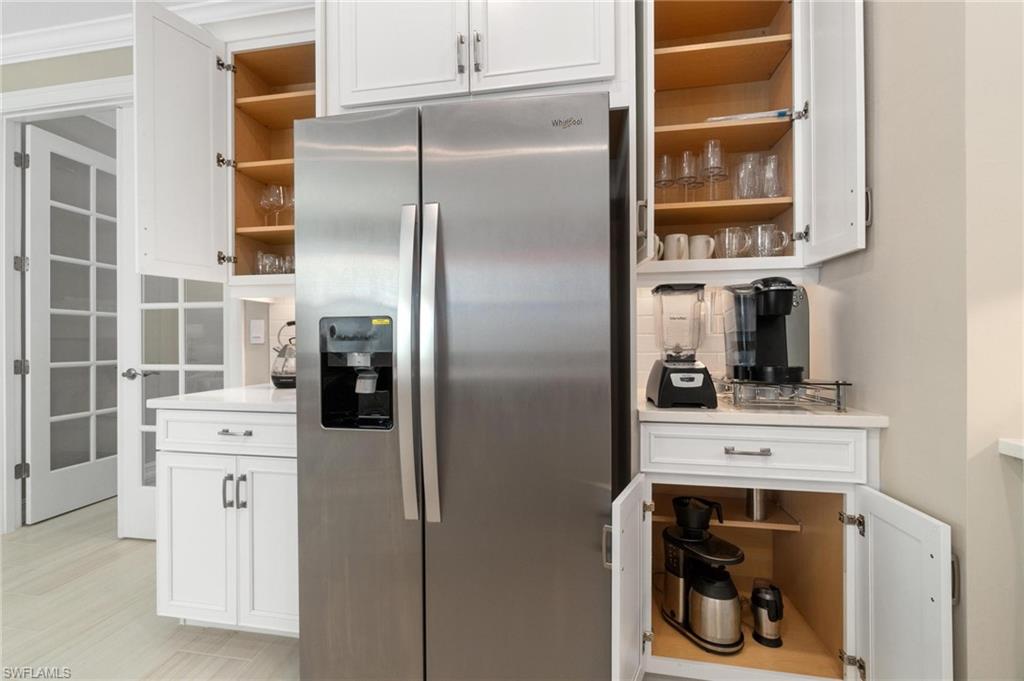 28298 Captiva Shell Loop Bonita Springs, FL 34135 - Photo 22 of 49 a kitchen with stainless steel appliances a refrigerator and a fireplace