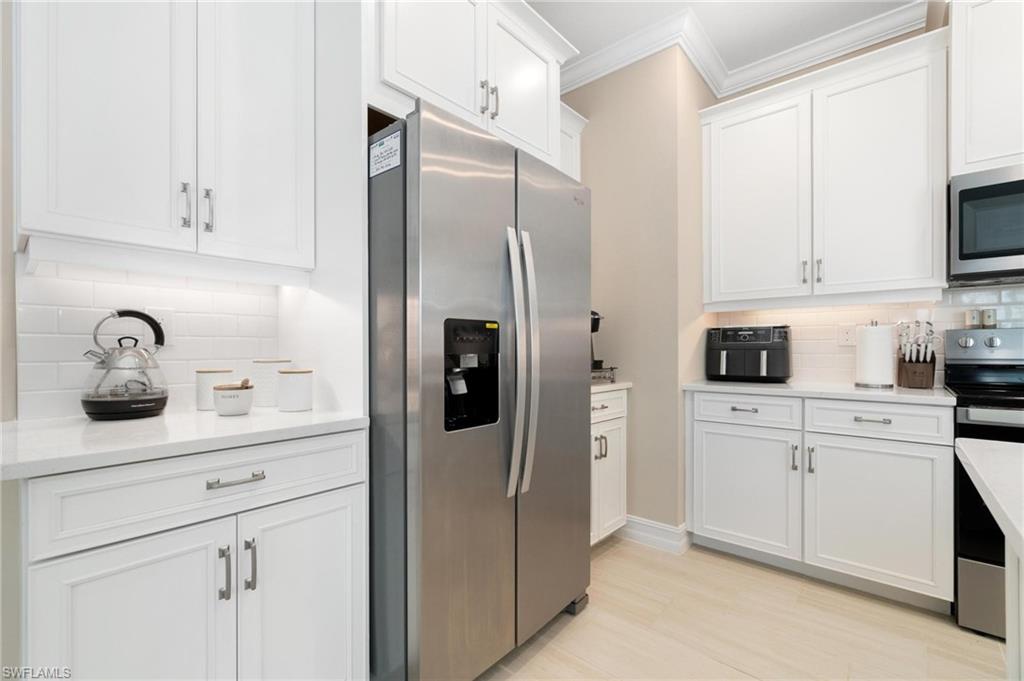 28298 Captiva Shell Loop Bonita Springs, FL 34135 - Photo 23 of 49 a kitchen with white cabinets and refrigerator