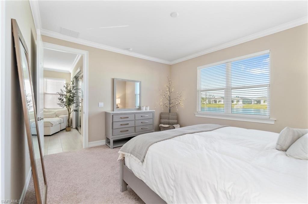 28298 Captiva Shell Loop Bonita Springs, FL 34135 - Photo 34 of 49 a bedroom with a balcony a bed and a chandelier