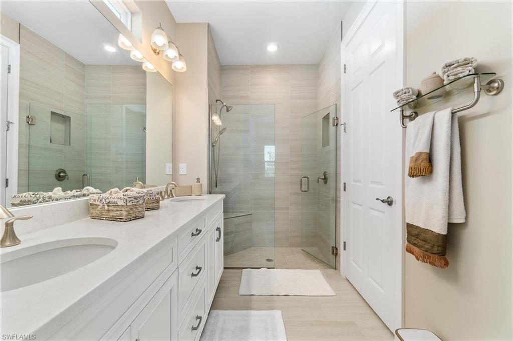28298 Captiva Shell Loop Bonita Springs, FL 34135 - Photo 36 of 49 a bathroom with a double vanity sink a large mirror and shower
