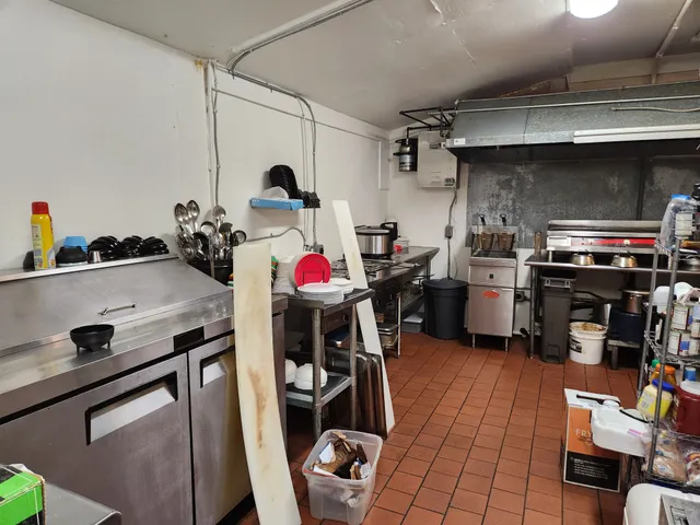 a utility room with stainless steel appliances and wooden floors