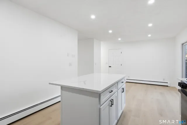 a view of a kitchen with refrigerator and white cabinets