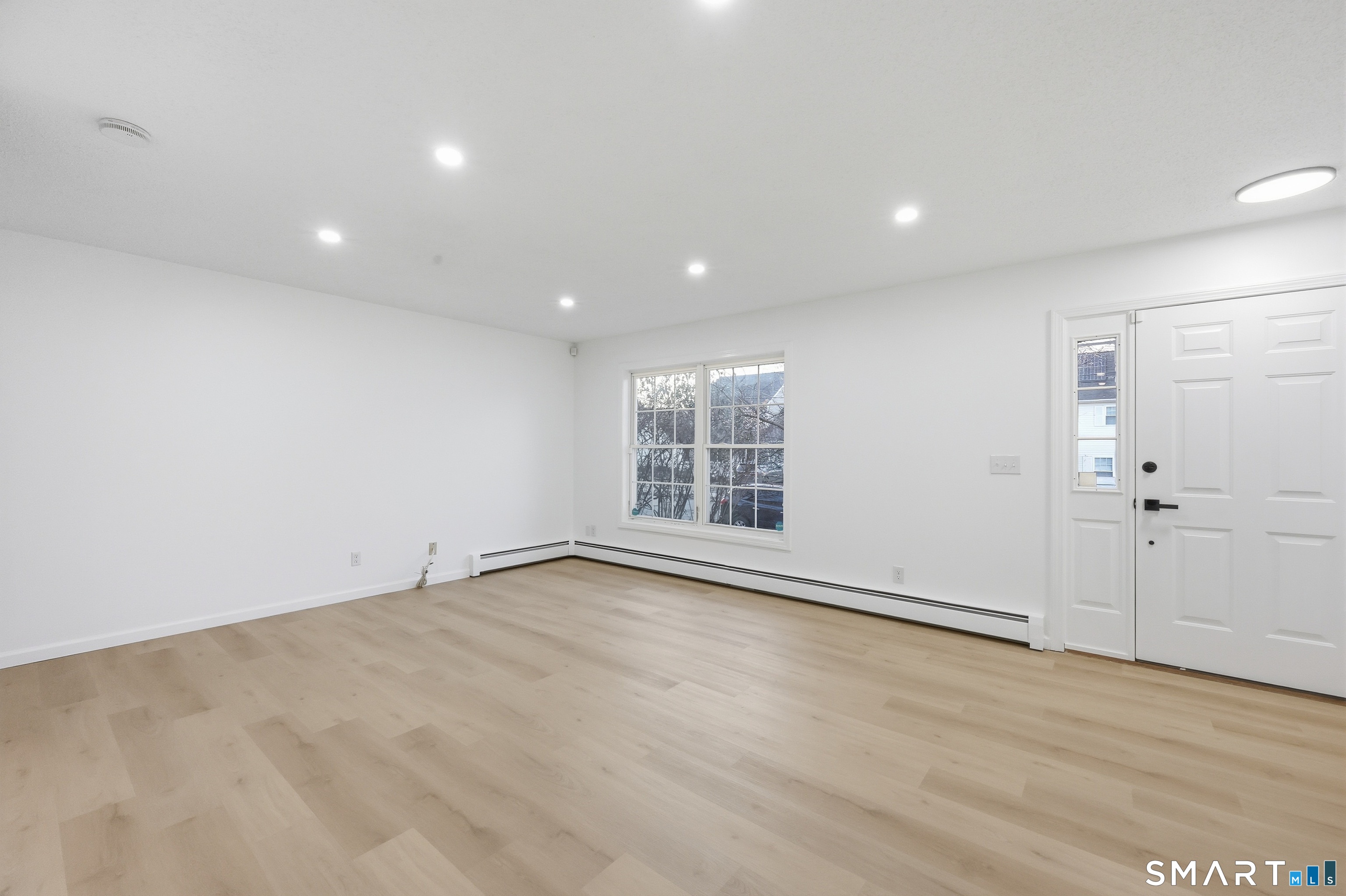 70 Victoria Court Hamden, CT 06514 - Photo 9 of 30 an empty room with wooden floor and windows