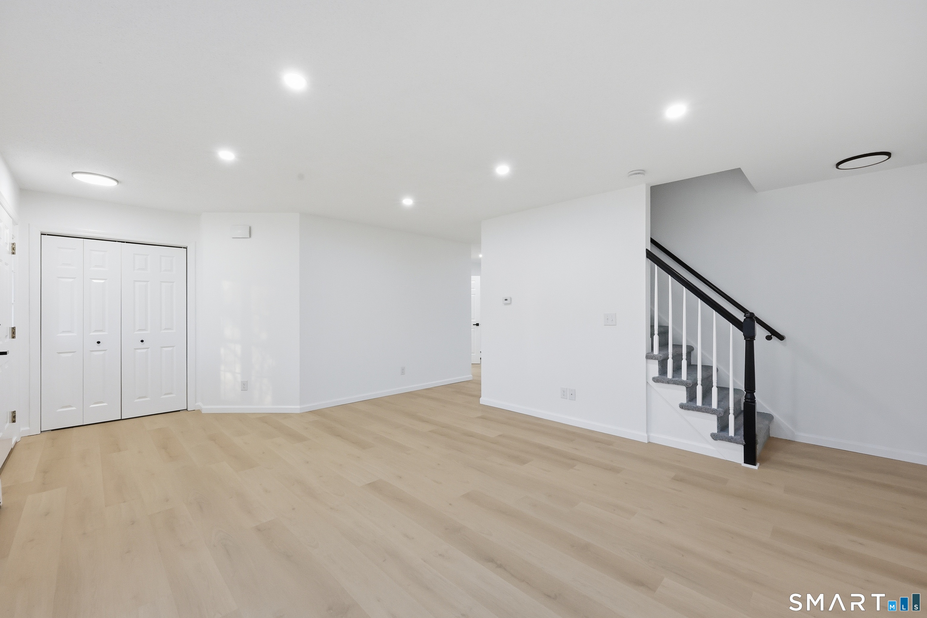 70 Victoria Court Hamden, CT 06514 - Photo 10 of 30 a view of an empty room with wooden floor and staircase