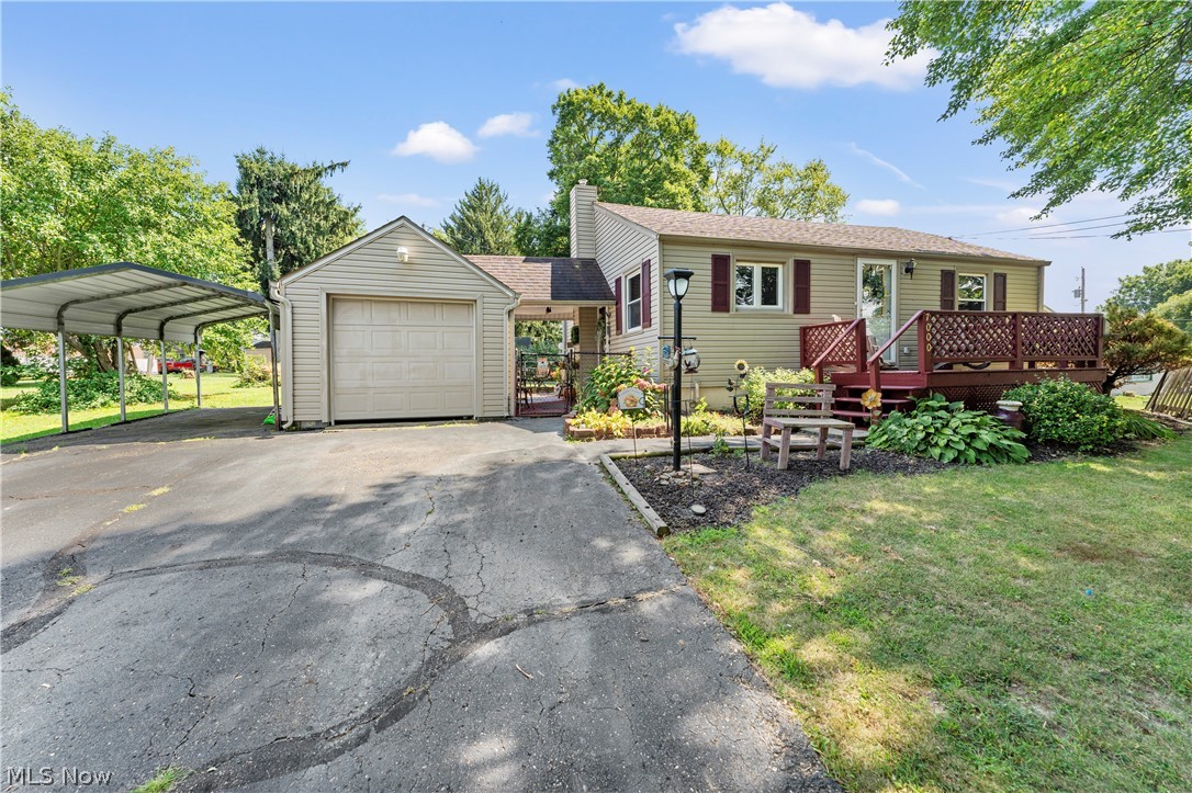 7000 Navarre Road Southwest Massillon, OH 44646 - Photo 2 of 22 The property features a one-car garage, an attached carport, and a front deck with railing