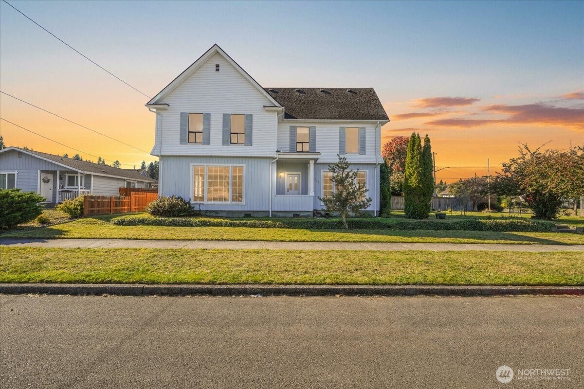 a front view of a house with a yard and swimming pool