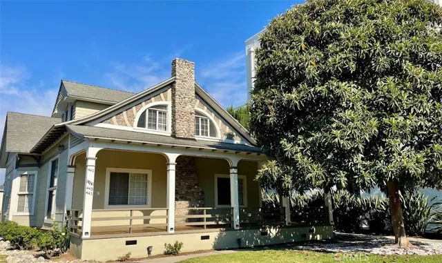a view of a white house with large windows and a tree