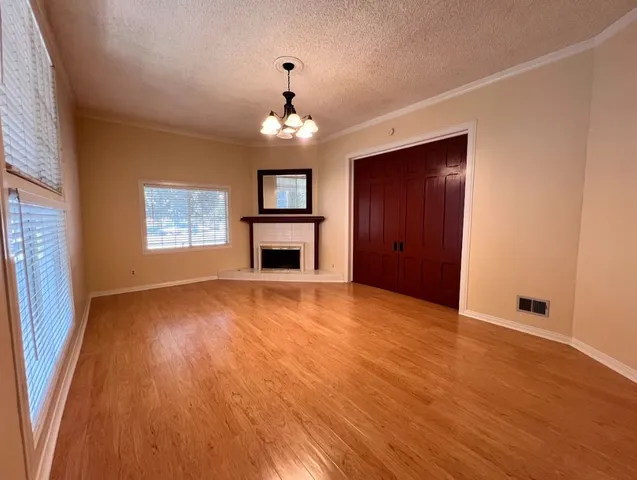 an empty room with windows and fireplace