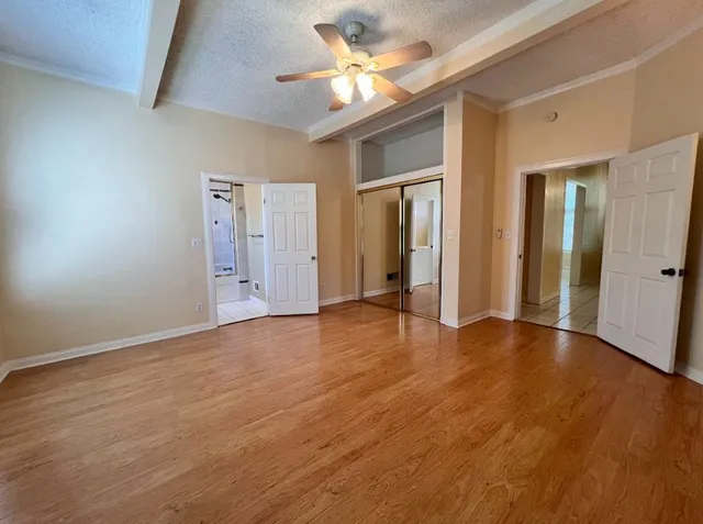 an empty room with closet and a chandelier fan