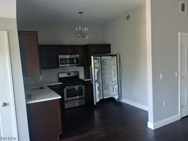 a kitchen with a refrigerator and a stove top oven