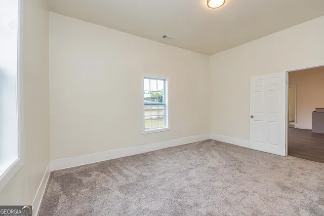 an empty room with closet and natural light