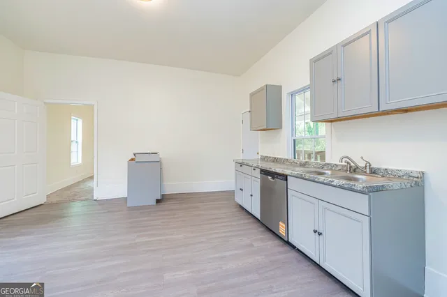 a view of a kitchen with furniture and wooden floor